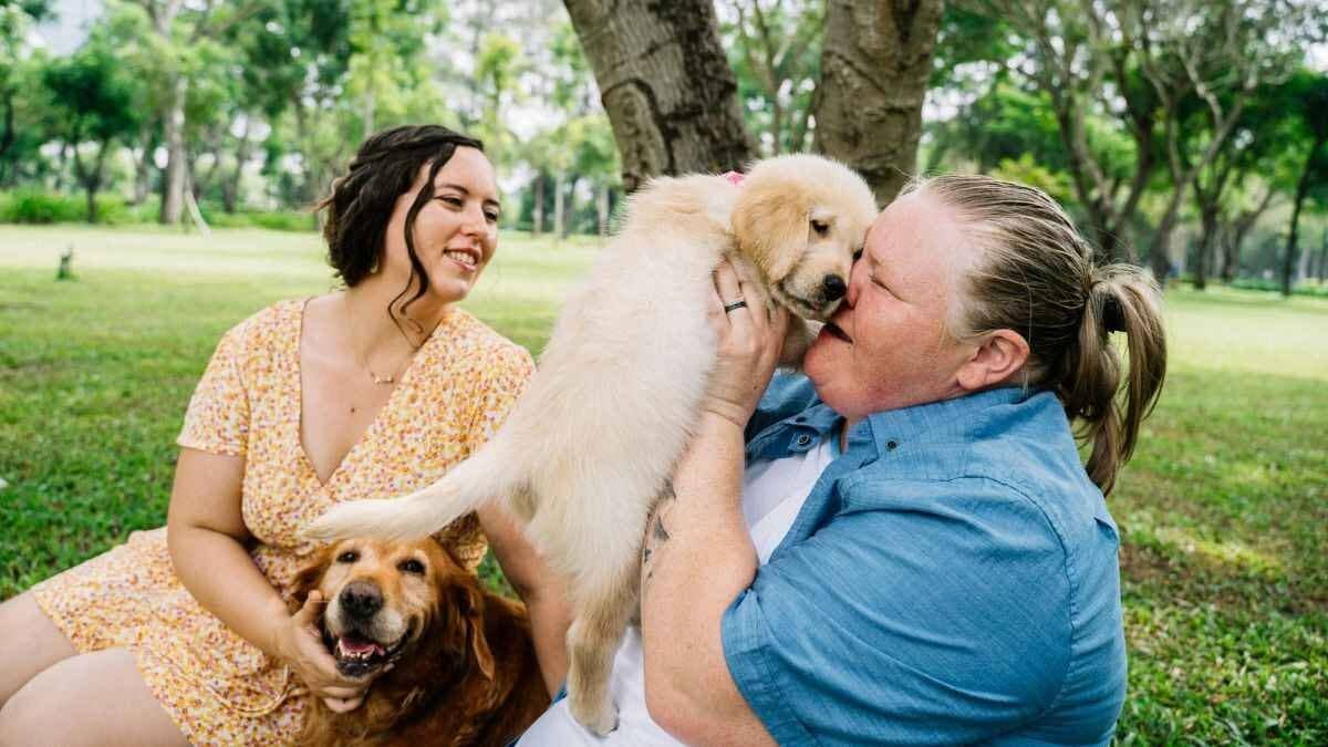 Two women playing with dogs
